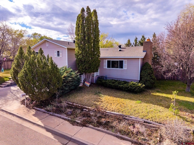 view of front of home with a front yard and a chimney