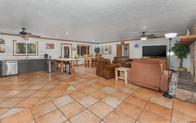 living room with a ceiling fan, a textured ceiling, and crown molding