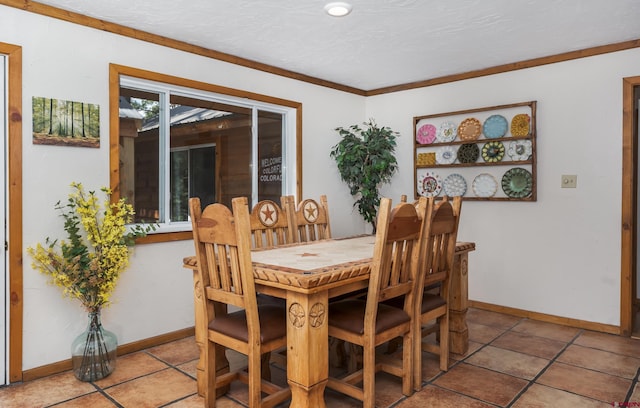 dining area featuring crown molding, tile patterned floors, and baseboards