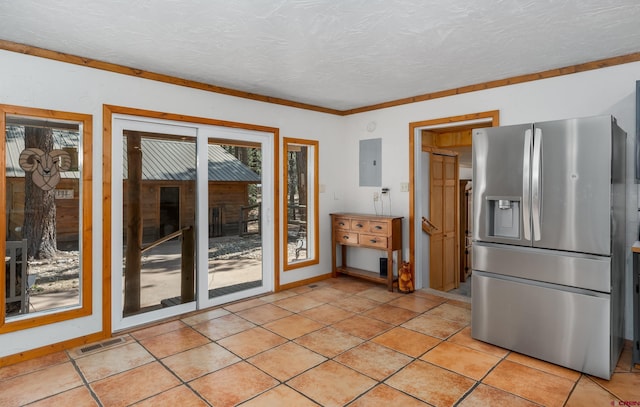 kitchen with electric panel, a textured ceiling, visible vents, and stainless steel fridge