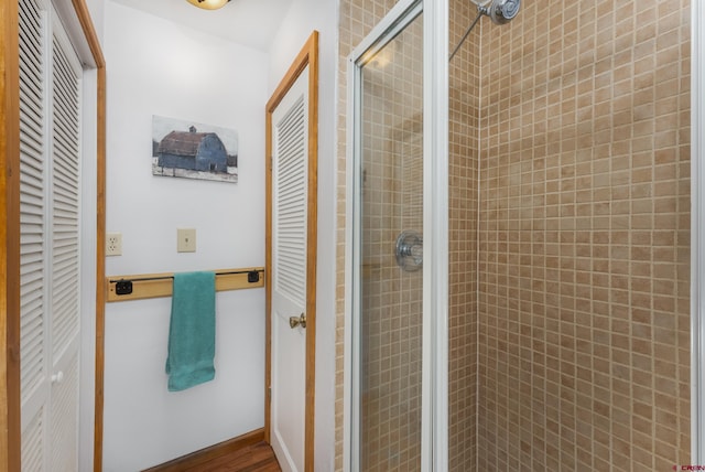 full bathroom featuring a shower stall and a closet
