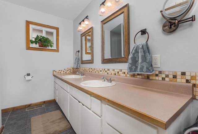 bathroom with baseboards, visible vents, a sink, and double vanity