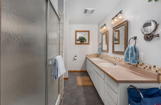 full bathroom with tile patterned floors, a sink, double vanity, decorative backsplash, and a shower stall