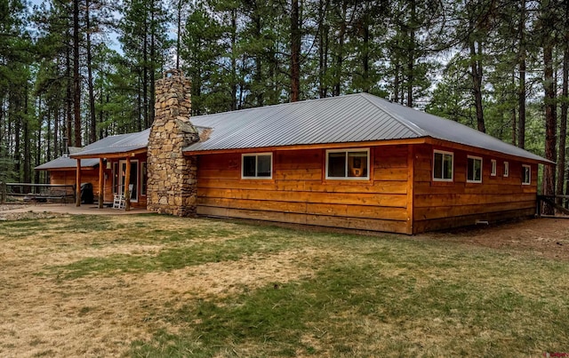 exterior space featuring a lawn and metal roof
