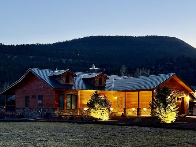 exterior space featuring a forest view, a mountain view, and metal roof