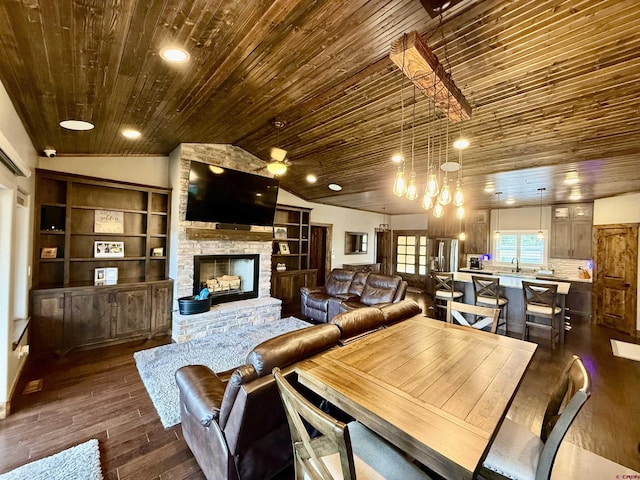 dining space with dark wood-type flooring, lofted ceiling, wooden ceiling, and a stone fireplace