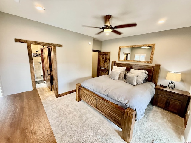 bedroom with connected bathroom, a ceiling fan, baseboards, and light colored carpet