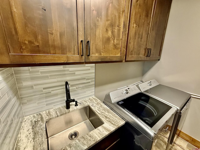 washroom with a sink, washer and dryer, and cabinet space