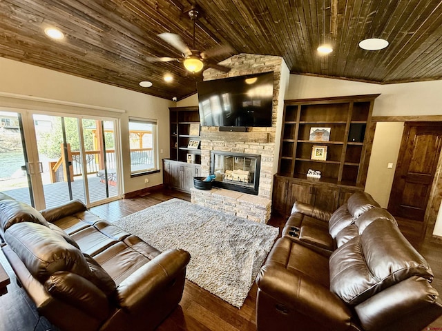living area with dark wood-style floors, vaulted ceiling, a stone fireplace, a ceiling fan, and wooden ceiling