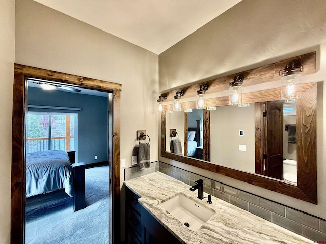 bathroom with vanity, ensuite bath, and backsplash