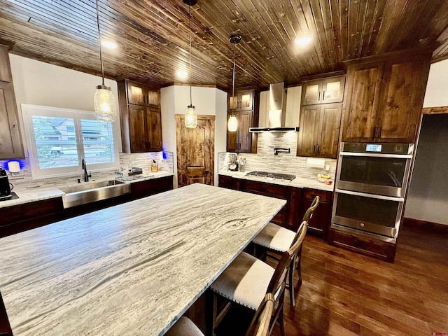 kitchen featuring wooden ceiling, a sink, wall chimney exhaust hood, glass insert cabinets, and appliances with stainless steel finishes