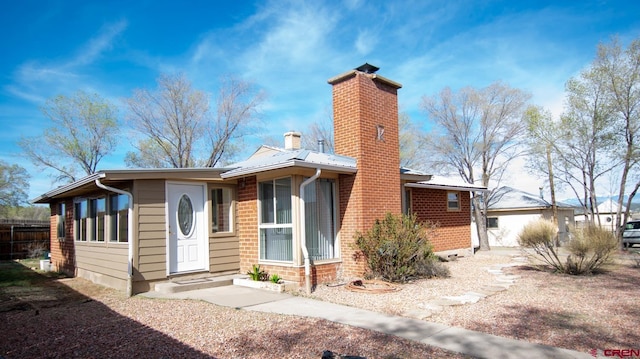 view of front of property with a chimney and fence