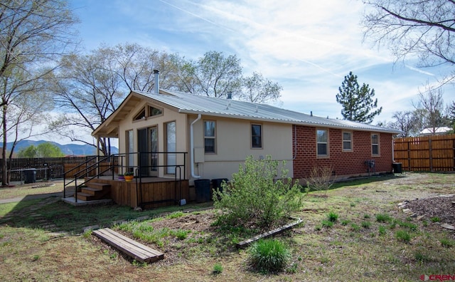 view of property exterior with fence and metal roof