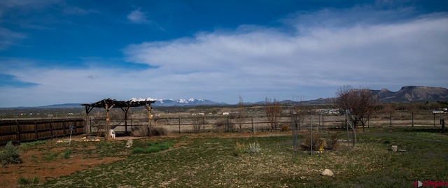 view of yard with fence and a mountain view