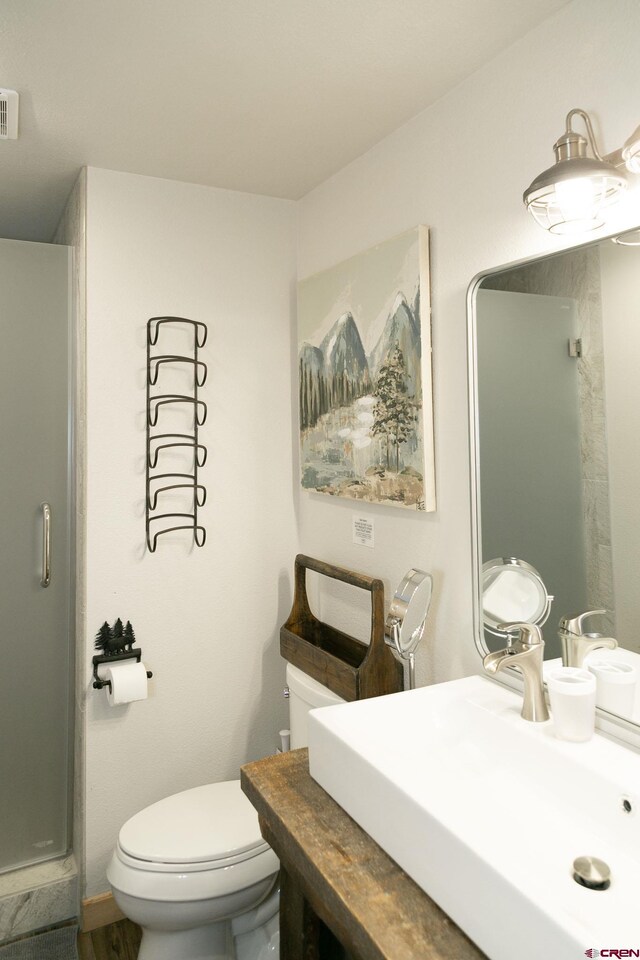bathroom featuring visible vents, toilet, a shower, and a sink