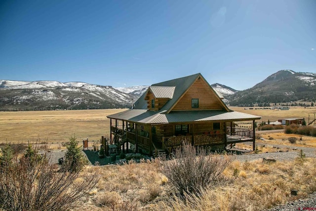 exterior space with a mountain view, a rural view, metal roof, and covered porch