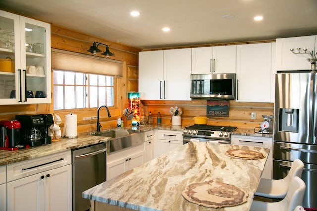 kitchen featuring appliances with stainless steel finishes, a sink, and white cabinetry