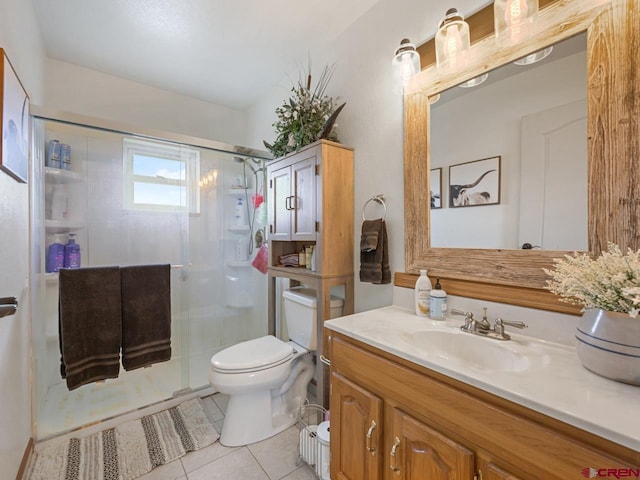 bathroom with toilet, vanity, tile patterned floors, and a stall shower