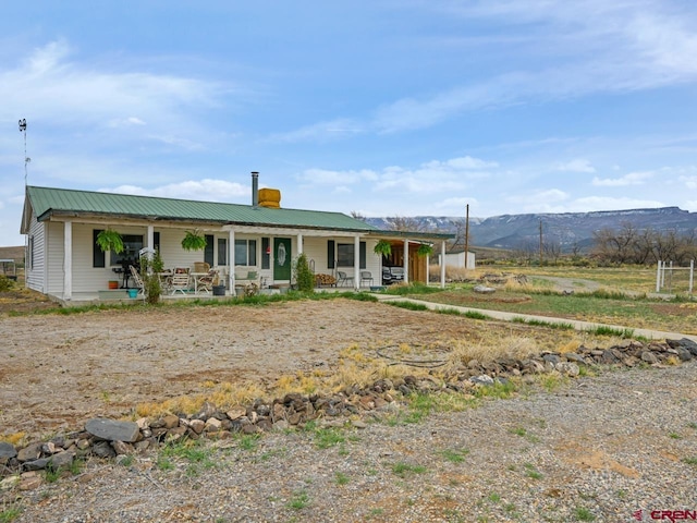 view of front of house with metal roof, covered porch, and a mountain view