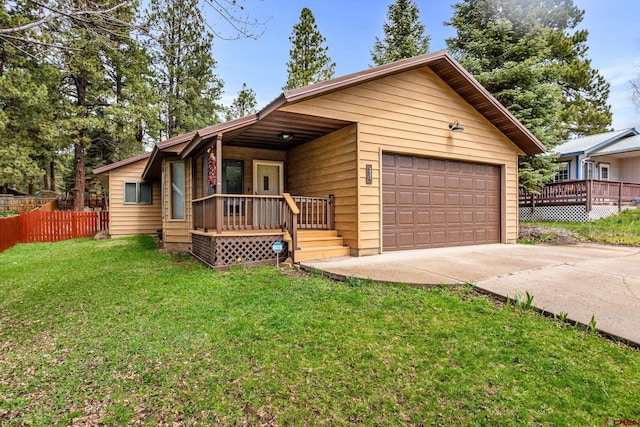 view of front of home featuring a front lawn, fence, a garage, and covered porch