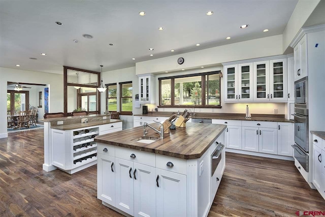 3575 E Rd, Palisade, CO 81526 - kitchen featuring a kitchen island with sink, stainless steel appliances, a sink, dark wood-style flooring, and wood counters