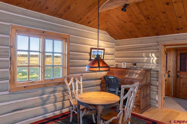 dining room with wood ceiling, rustic walls, lofted ceiling, and light wood finished floors