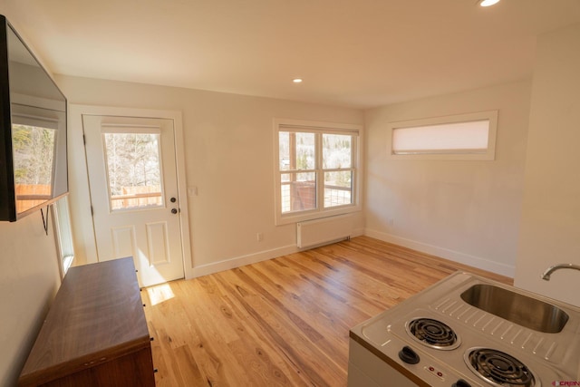 interior space with recessed lighting, baseboards, light wood-type flooring, and plenty of natural light