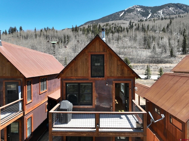 snow covered rear of property featuring a mountain view