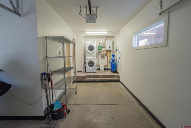 interior space featuring a garage, stacked washer and clothes dryer, tankless water heater, and laundry area