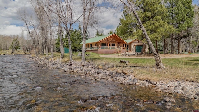 rear view of property with a porch and a water view
