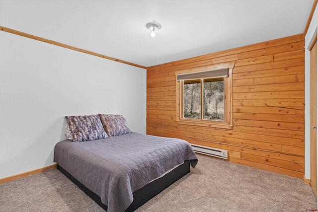 carpeted bedroom featuring a baseboard heating unit and wooden walls