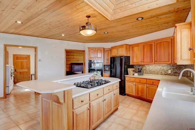kitchen featuring backsplash, a sink, washing machine and clothes dryer, wood ceiling, and black appliances