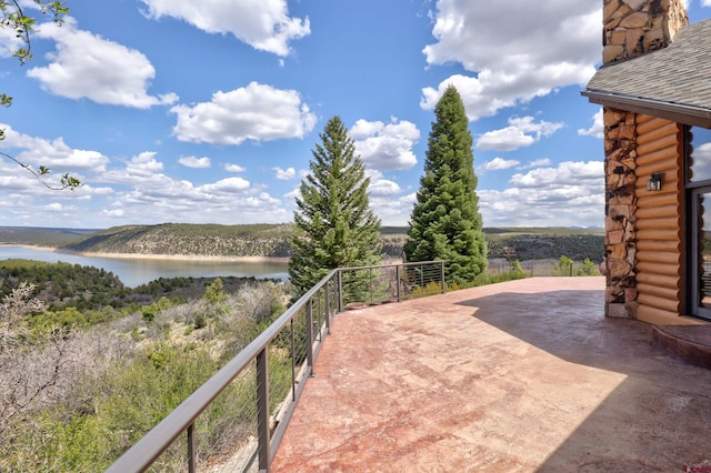 view of patio / terrace with a balcony and a water view