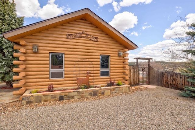 view of side of home with fence and log siding