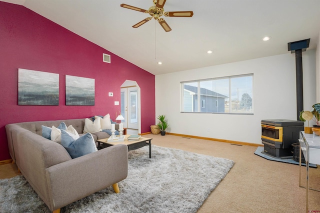 carpeted living area with a ceiling fan, a wood stove, lofted ceiling, visible vents, and recessed lighting