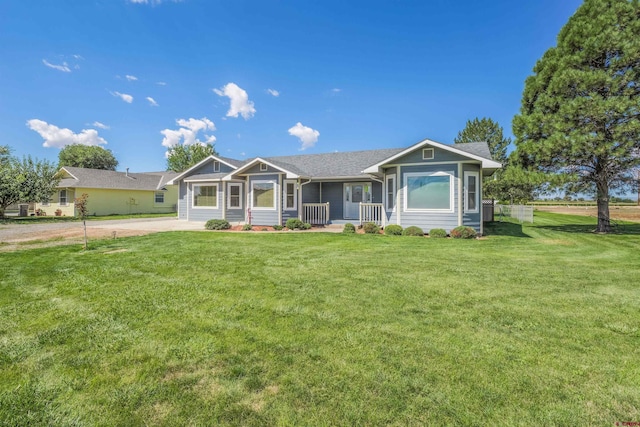 ranch-style home featuring driveway, covered porch, and a front yard