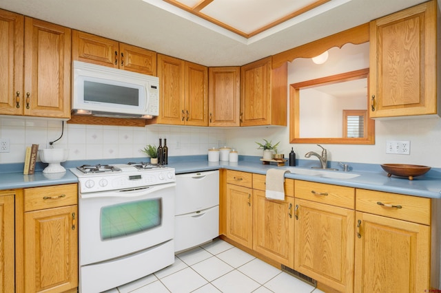 kitchen featuring tasteful backsplash, visible vents, a sink, and white appliances