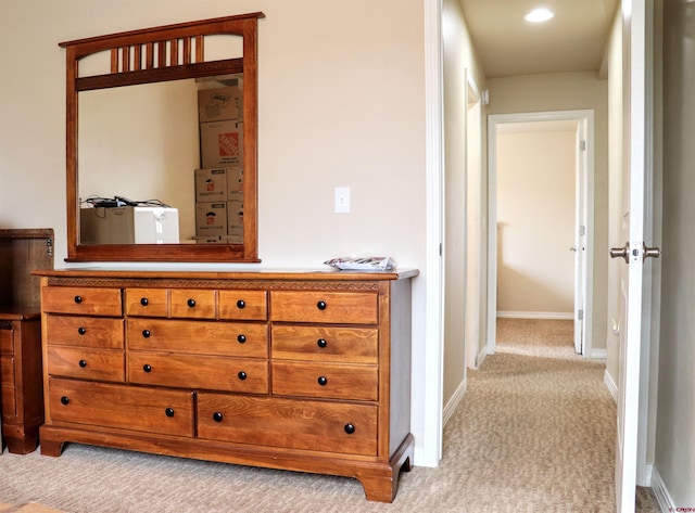 hallway with light colored carpet and baseboards