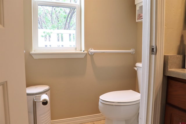 half bath with baseboards and toilet