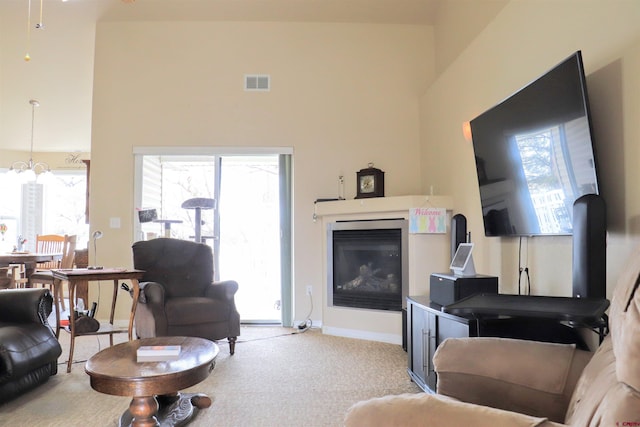 living room featuring plenty of natural light, baseboards, visible vents, and carpet flooring