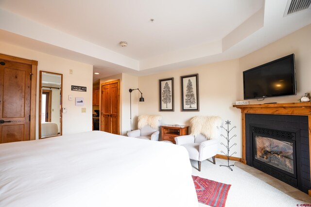 620 Gothic Rd Unit 403, Mount Crested Butte, CO 81225 - bedroom featuring a fireplace with flush hearth, light colored carpet, and a tray ceiling