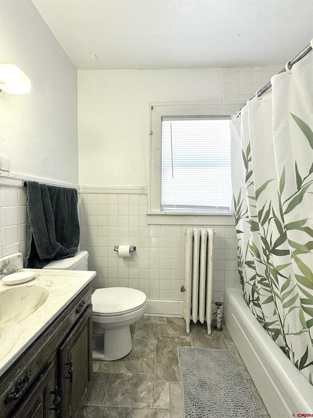 212 Bell Ave, Alamosa, CO 81101 - bathroom with tile walls, radiator, toilet, vanity, and shower / tub combo with curtain
