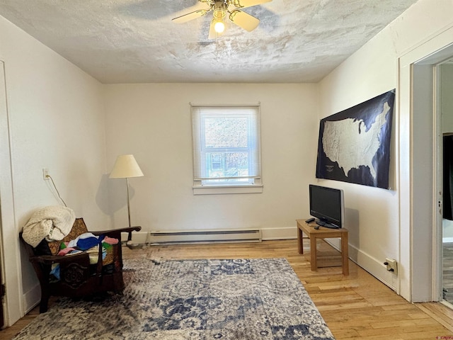 212 Bell Ave, Alamosa, CO 81101 - living area featuring light wood-type flooring, a ceiling fan, and a baseboard radiator