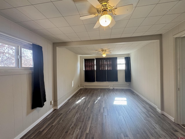 212 Bell Ave, Alamosa, CO 81101 - spare room with dark wood-style floors, baseboards, ceiling fan, and a baseboard radiator