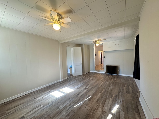 212 Bell Ave, Alamosa, CO 81101 - spare room with baseboards, a ceiling fan, radiator heating unit, and dark wood-type flooring