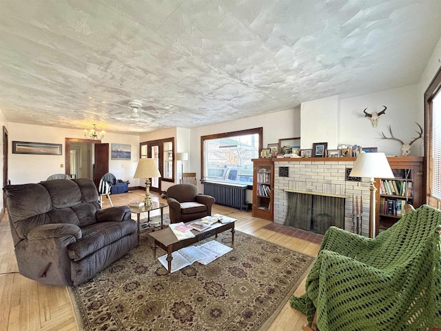 212 Bell Ave, Alamosa, CO 81101 - living area featuring radiator, a ceiling fan, hardwood / wood-style floors, and a fireplace