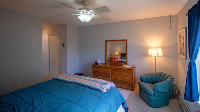 carpeted bedroom with baseboard heating, baseboards, a ceiling fan, and a closet