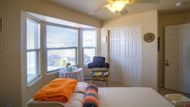carpeted bedroom featuring a closet, multiple windows, and a ceiling fan