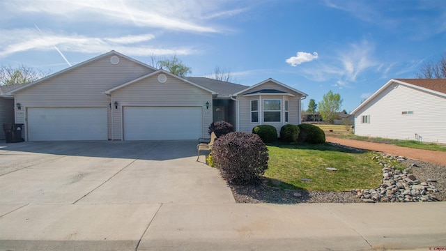 single story home with driveway, a front yard, and an attached garage