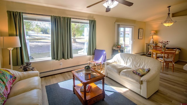 living area featuring vaulted ceiling, wood finished floors, a ceiling fan, and baseboard heating